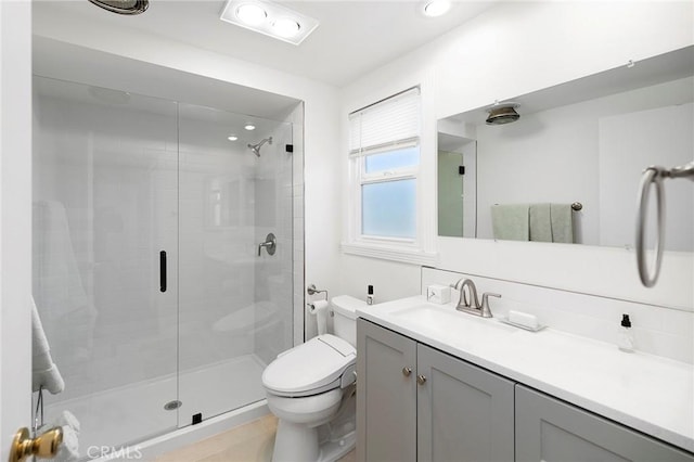 bathroom with toilet, an enclosed shower, decorative backsplash, and vanity