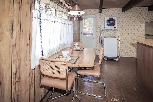 dining area featuring washer / clothes dryer and beam ceiling