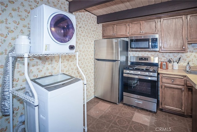 kitchen featuring beam ceiling, appliances with stainless steel finishes, wood ceiling, and washer / clothes dryer