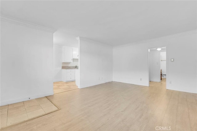 empty room with crown molding and light wood-type flooring