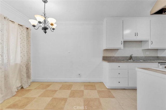 kitchen with white cabinets, backsplash, hanging light fixtures, and ornamental molding