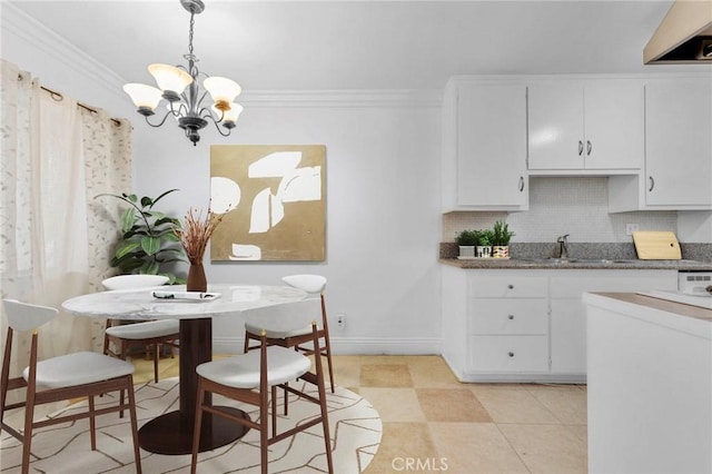 dining room featuring sink, an inviting chandelier, and ornamental molding