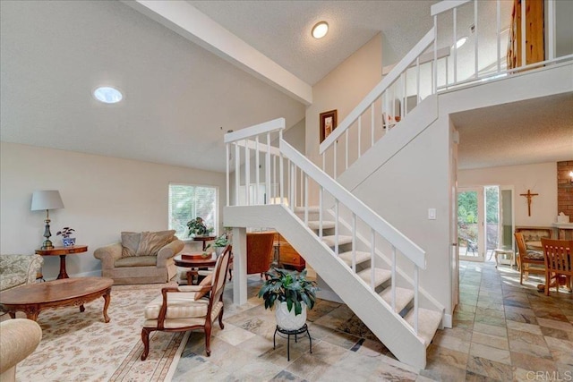 stairway featuring a wealth of natural light and high vaulted ceiling