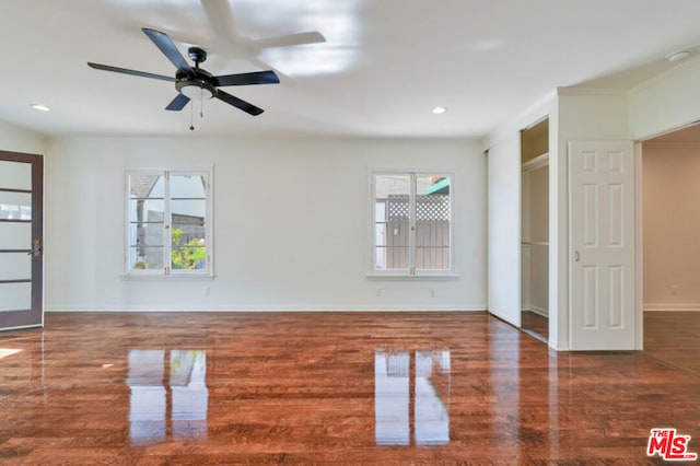 unfurnished living room with crown molding, ceiling fan, and dark wood-type flooring