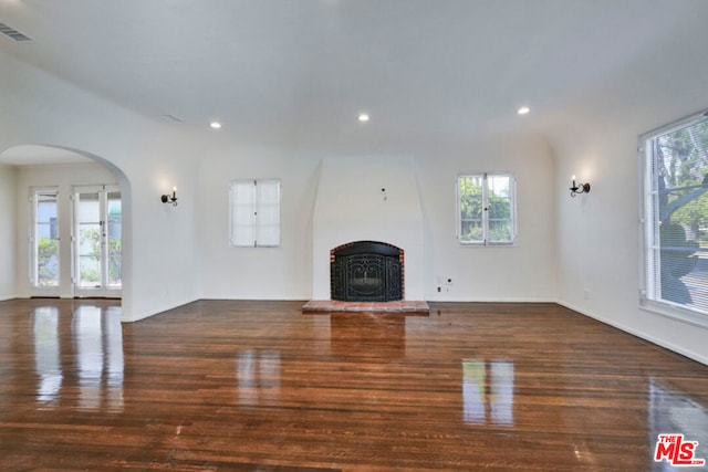 unfurnished living room featuring dark hardwood / wood-style flooring and plenty of natural light