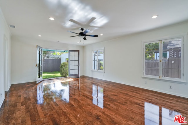 unfurnished living room with ceiling fan, french doors, and dark wood-type flooring