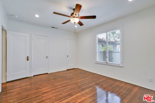 unfurnished bedroom with ceiling fan, dark hardwood / wood-style flooring, and ornamental molding