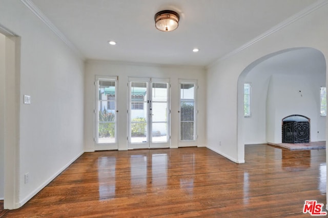 unfurnished living room featuring crown molding, french doors, and wood-type flooring