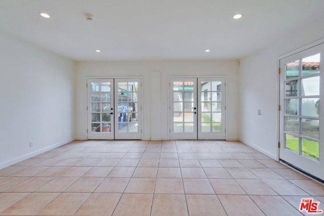 doorway with a wealth of natural light, french doors, and light tile patterned flooring