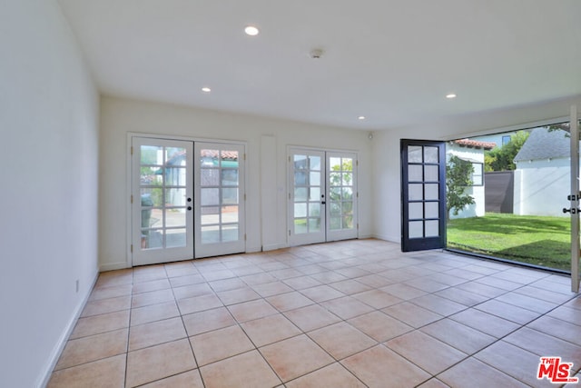 entryway with light tile patterned floors, a wealth of natural light, and french doors