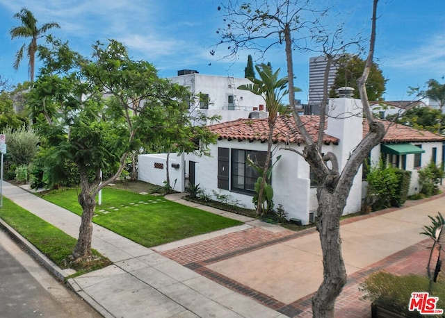 mediterranean / spanish-style home with a front lawn