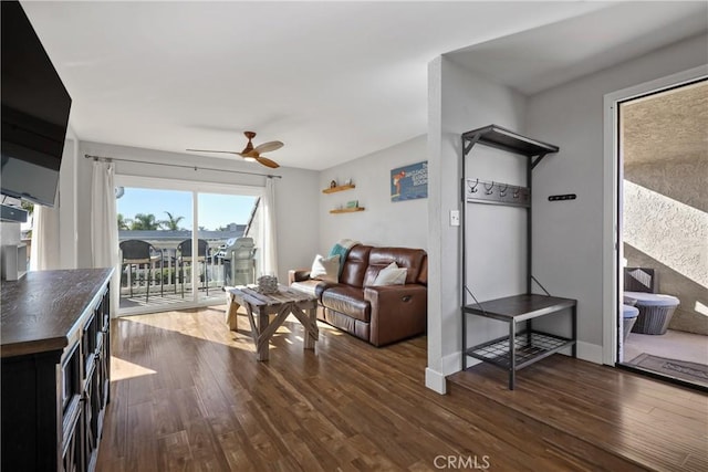 living room featuring ceiling fan and dark hardwood / wood-style floors