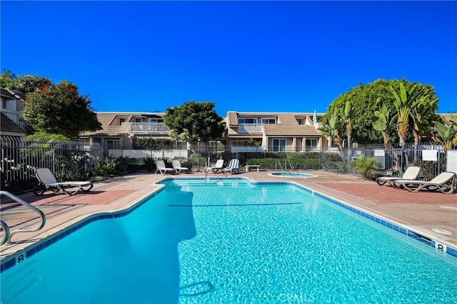 view of swimming pool with a community hot tub and a patio