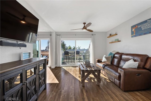 living room featuring dark wood-type flooring and ceiling fan