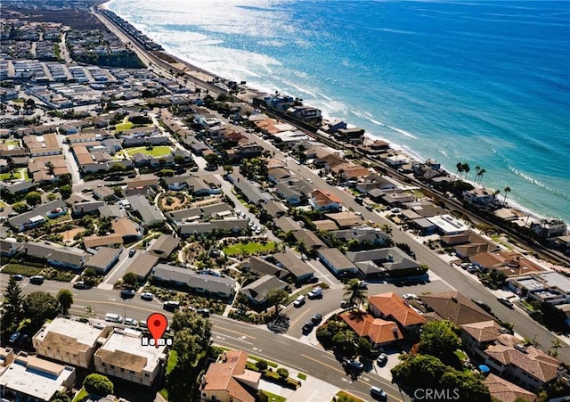 birds eye view of property featuring a water view and a beach view