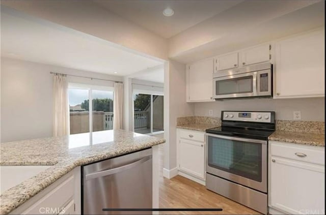 kitchen featuring white cabinetry, appliances with stainless steel finishes, and light stone counters