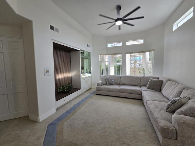 carpeted living room with ceiling fan and a wealth of natural light