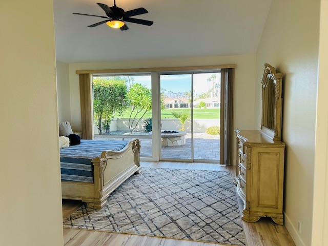 bedroom with vaulted ceiling, access to outside, light hardwood / wood-style flooring, and ceiling fan