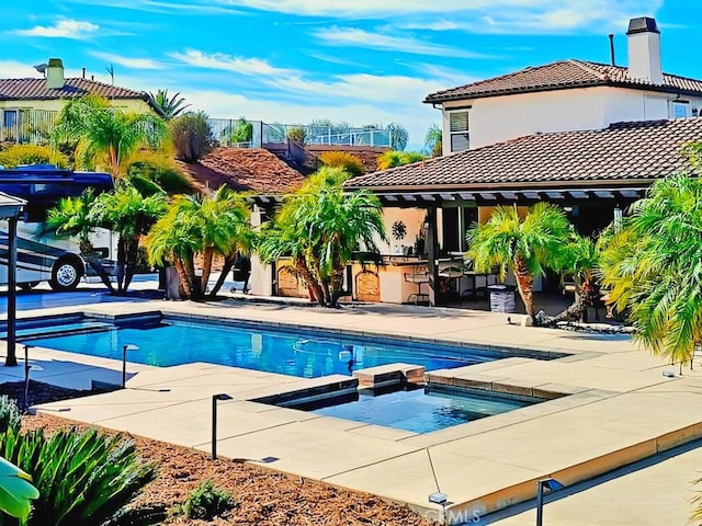 view of pool featuring an in ground hot tub and a patio