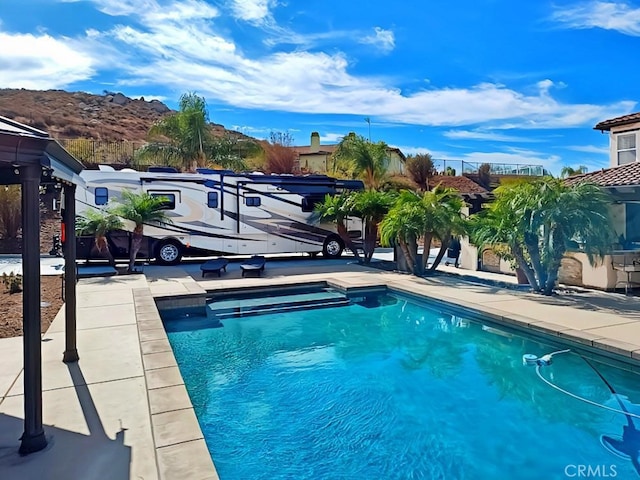 view of pool featuring a mountain view and a patio area