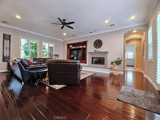 living room with ceiling fan, dark wood-type flooring, and ornamental molding