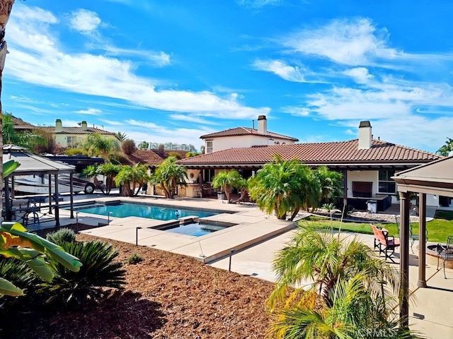 view of swimming pool with an in ground hot tub and a patio