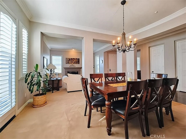 carpeted dining space featuring a wealth of natural light, a chandelier, and ornamental molding