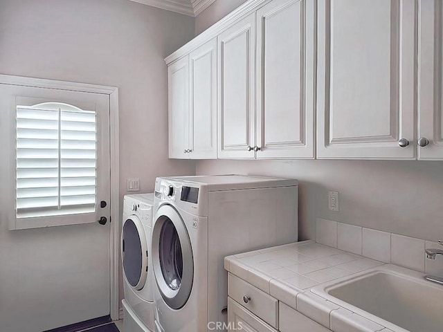 laundry room with washer and clothes dryer, sink, cabinets, and crown molding