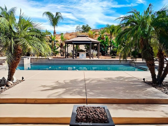 view of swimming pool featuring a gazebo, an outdoor fire pit, and a patio