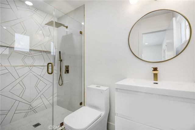 bathroom with vanity, a shower with shower door, and toilet