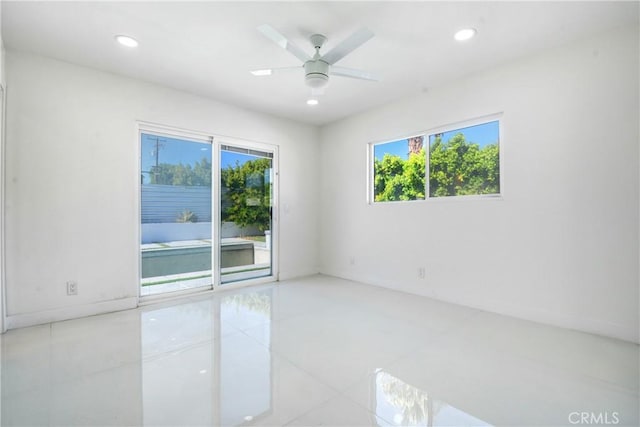 tiled spare room with ceiling fan