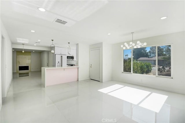 interior space with a notable chandelier, light tile patterned floors, and a fireplace