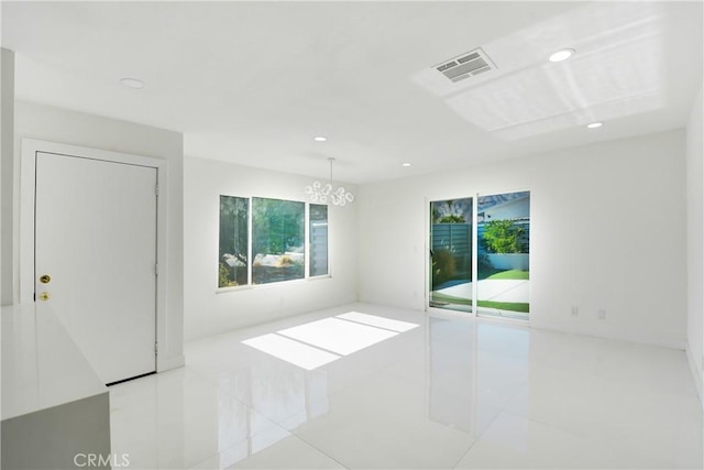 unfurnished room with a notable chandelier and light tile patterned flooring