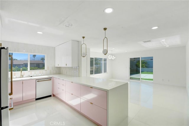 kitchen featuring hanging light fixtures, kitchen peninsula, dishwasher, and a healthy amount of sunlight