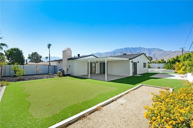 rear view of house featuring a mountain view and a patio area