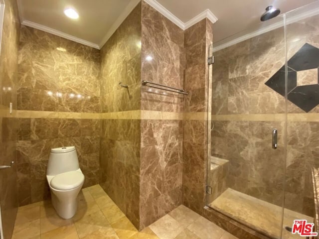 bathroom featuring tile walls, toilet, ornamental molding, and an enclosed shower