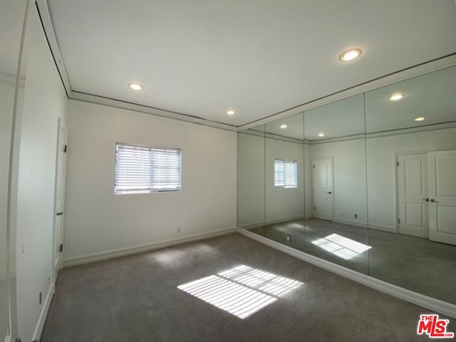 carpeted empty room featuring ornamental molding