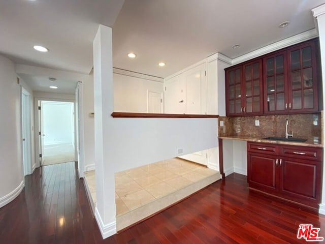 interior space featuring dark wood-type flooring, tasteful backsplash, and sink