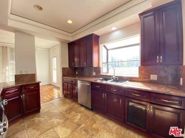 kitchen featuring stainless steel dishwasher, decorative backsplash, sink, and stone countertops