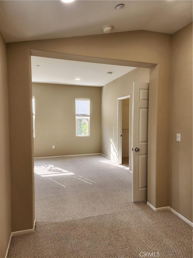 carpeted empty room featuring lofted ceiling