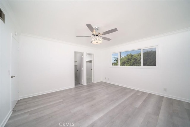 unfurnished bedroom with ceiling fan, crown molding, a walk in closet, a closet, and light wood-type flooring