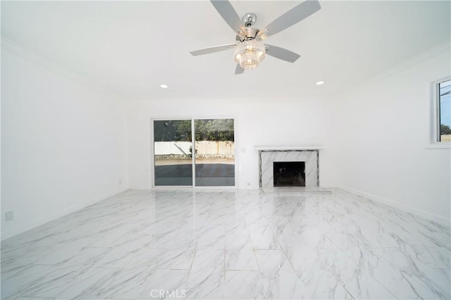 unfurnished living room featuring ceiling fan, ornamental molding, and a premium fireplace