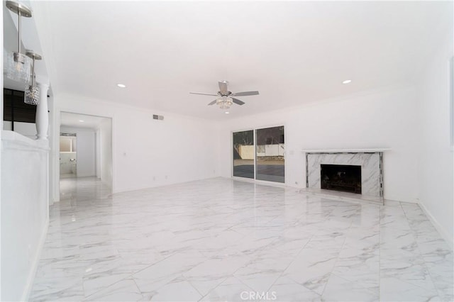 unfurnished living room with ceiling fan, a fireplace, and crown molding