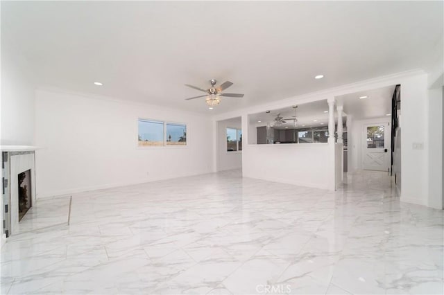 unfurnished living room with ceiling fan and crown molding