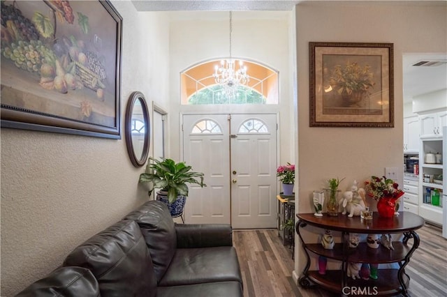 foyer entrance with hardwood / wood-style floors and a chandelier