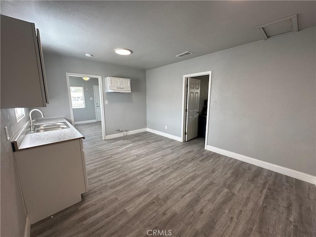 kitchen with sink, white cabinets, dark wood-type flooring, and a textured ceiling