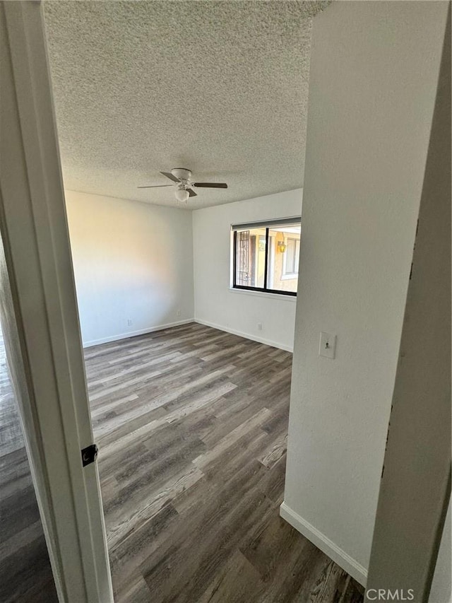 empty room featuring hardwood / wood-style flooring, a textured ceiling, and ceiling fan