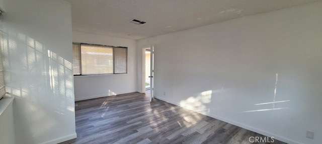 unfurnished room with dark hardwood / wood-style floors