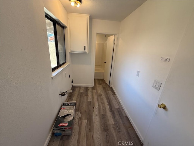 hall featuring baseboards and dark wood-style flooring