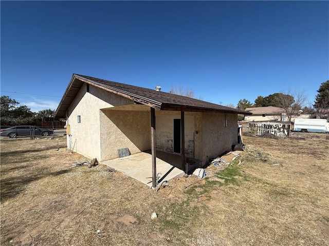 rear view of house with stucco siding and a patio